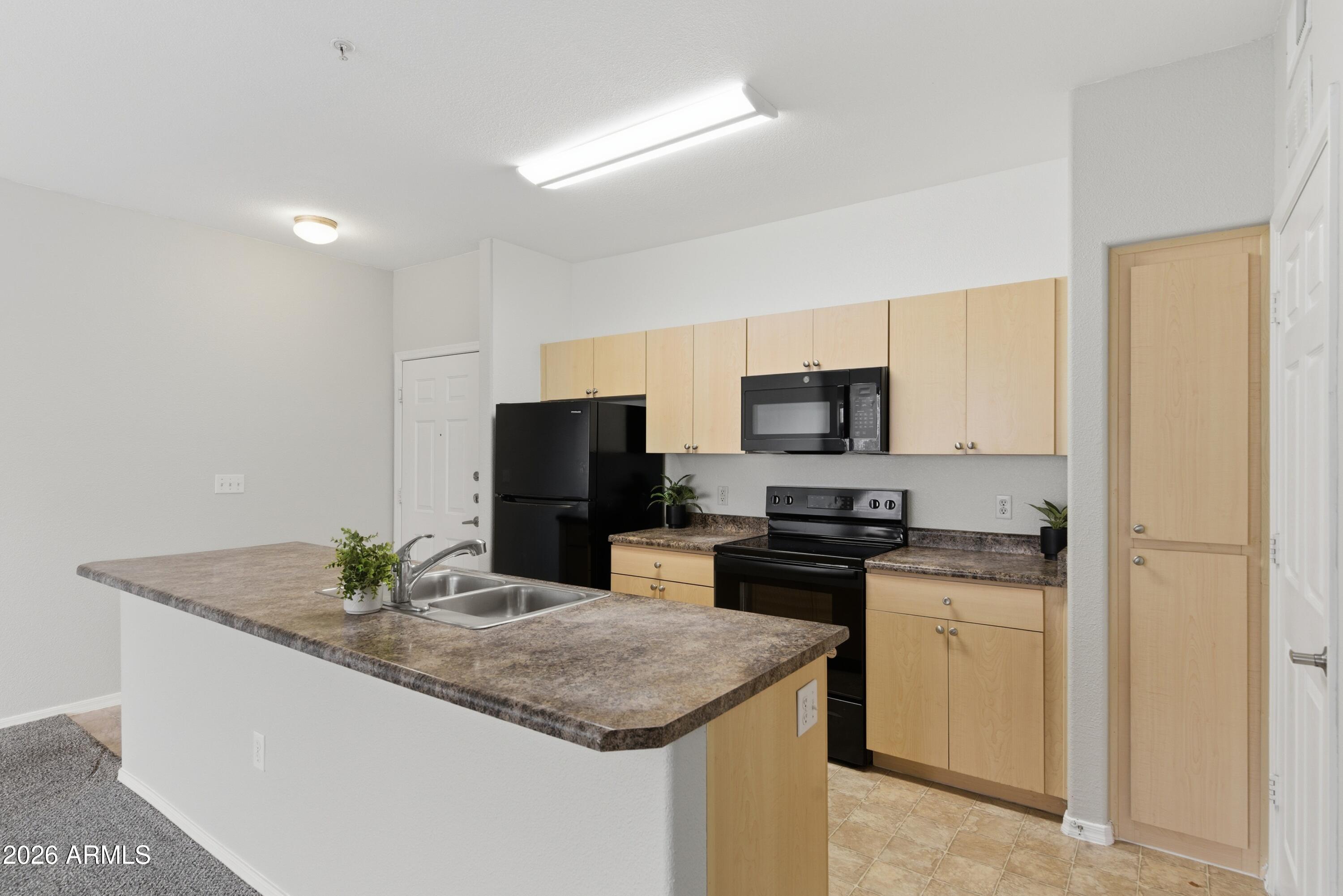 18416 North Cave Creek Road, Unit 3057 Phoenix, AZ 85032 - Photo 8 of 21 a kitchen with stainless steel appliances granite countertop a sink a stove a microwave a counter top space and cabinets
