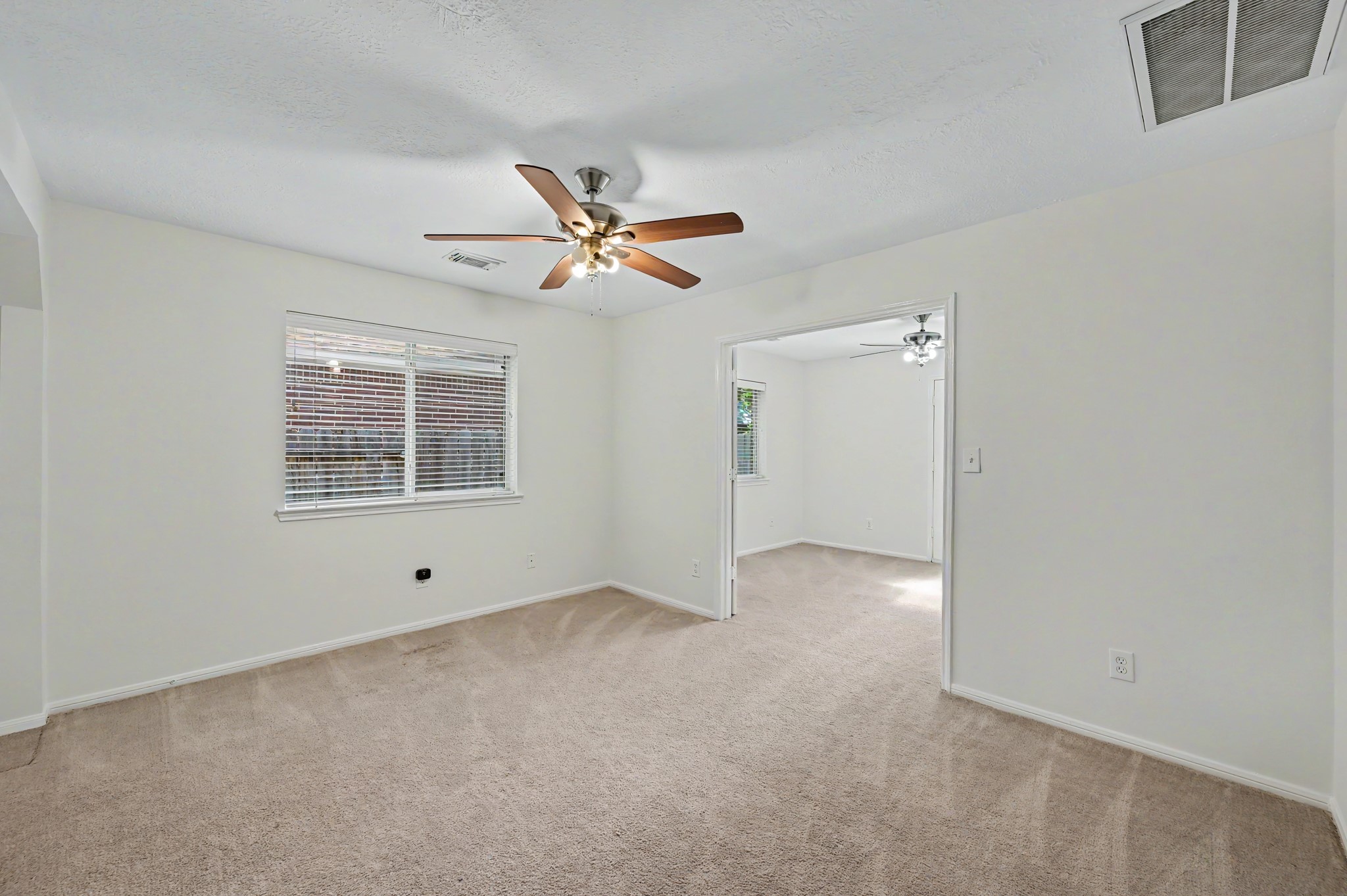 14 South Rambling Ridge Place The Woodlands, TX 77385 - Photo 26 of 42 Spacious secondary bedroom with soft neutral finishes, ceiling fan, and an open adjoining flex room.