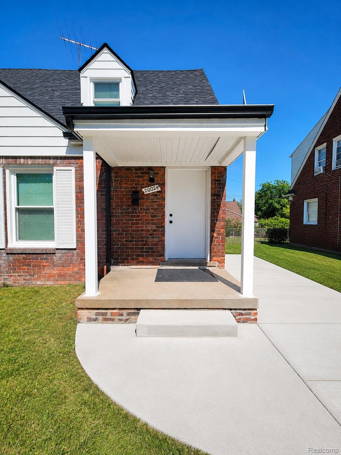 20024 Meyers Road Detroit, MI 48235 - Photo 2 of 16 Brick facade with white siding accents and a covered front porch featuring white columns
