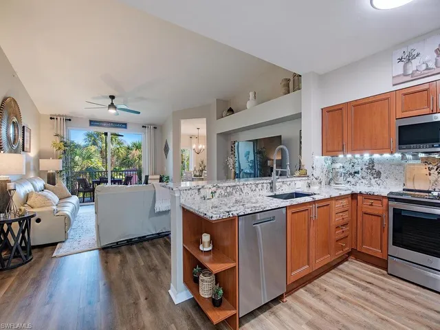 a kitchen with kitchen island granite countertop a sink stove and wooden floor