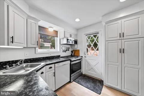 a kitchen with granite countertop a sink stove and refrigerator