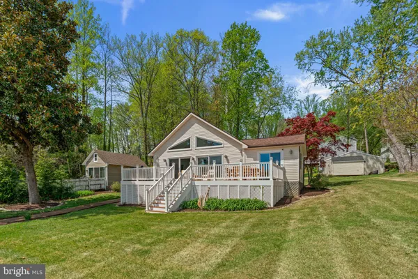 a view of a house with a big yard and large trees