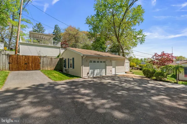 a view of a house with a small yard and a large tree