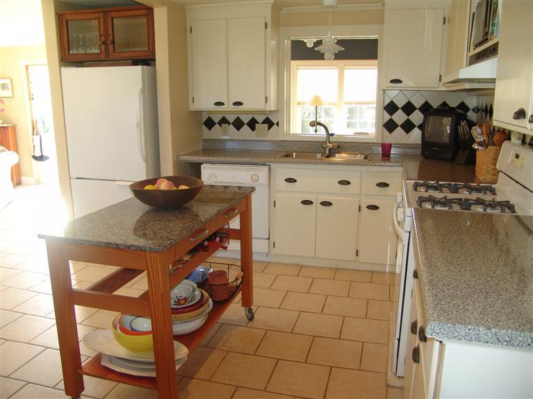 65 Bay Shore Road Hyannis, MA 02601 - Photo 4 of 35 a kitchen with granite countertop a sink a stove and a wooden cabinets