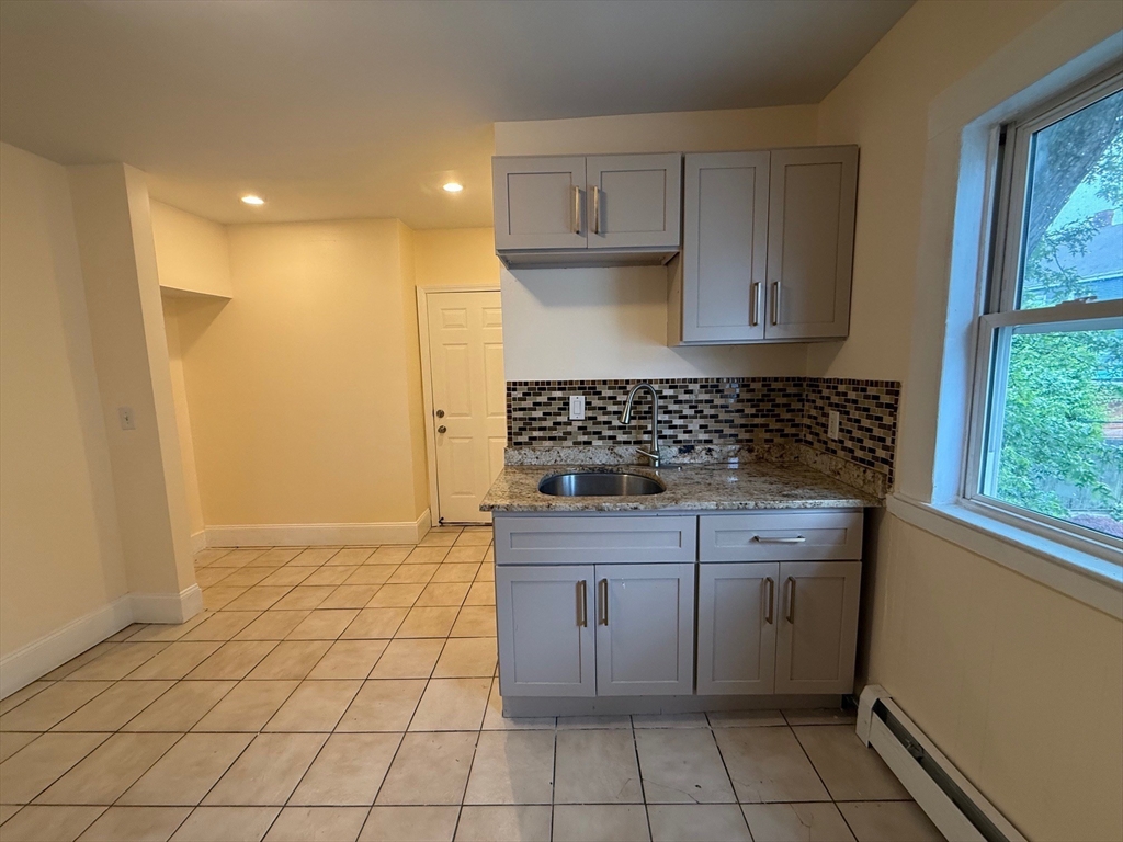 11 Dalrymple Street, Unit 3 Boston, MA 02130 - Photo 11 of 13 a kitchen with a sink a stove and cabinets