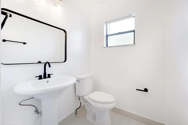 a bathroom with a sink mirror and toilet
