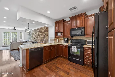 a kitchen with stainless steel appliances granite countertop a sink stove and refrigerator