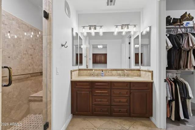 a bathroom with a double vanity sink mirror and shower