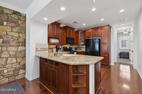 a kitchen with stainless steel appliances a stove a chimney a sink and a refrigerator