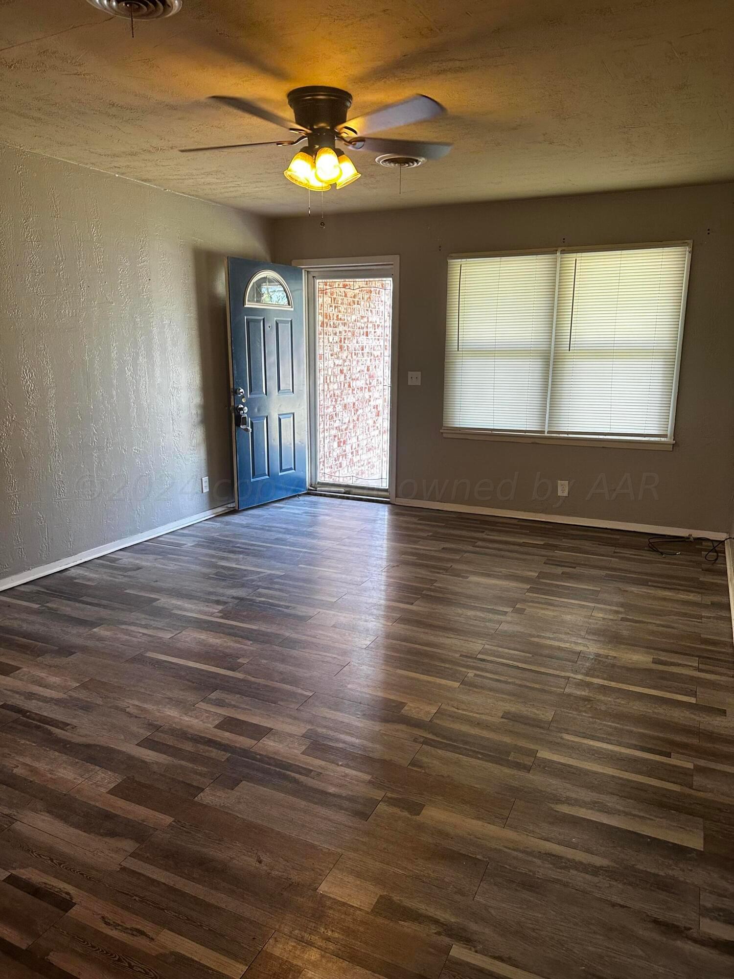 4209 Mesa Circle Amarillo, TX 79109 - Photo 2 of 9 a view of an empty room with window and wooden floor