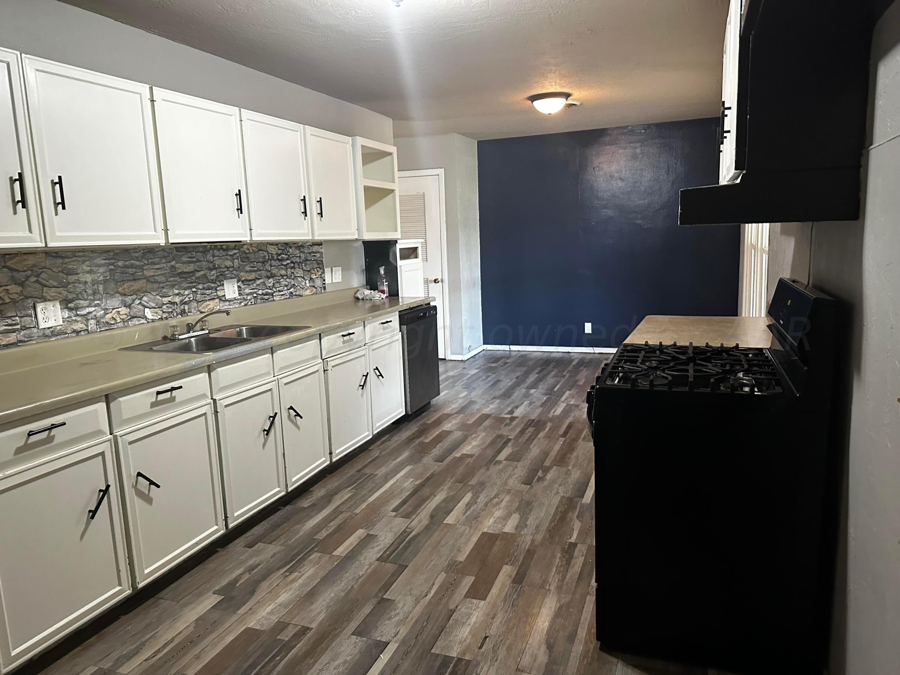 4209 Mesa Circle Amarillo, TX 79109 - Photo 5 of 9 a kitchen with granite countertop white cabinets and black appliances