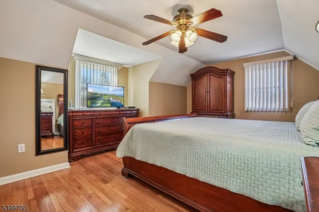 a bedroom with a bed dresser and wooden floor