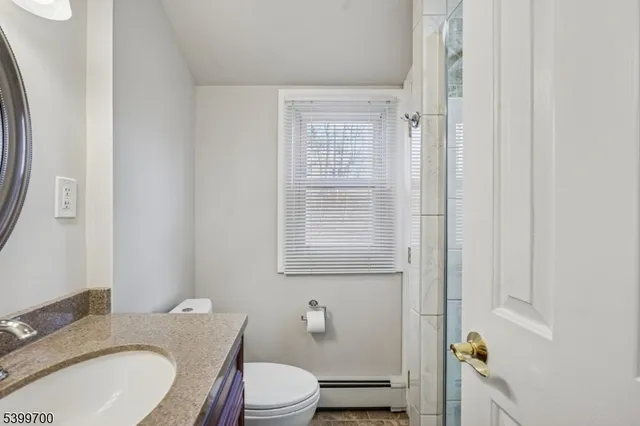 a bathroom with a granite countertop toilet sink and mirror