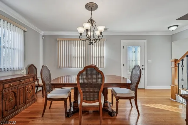 a dining room with furniture a chandelier and wooden floor