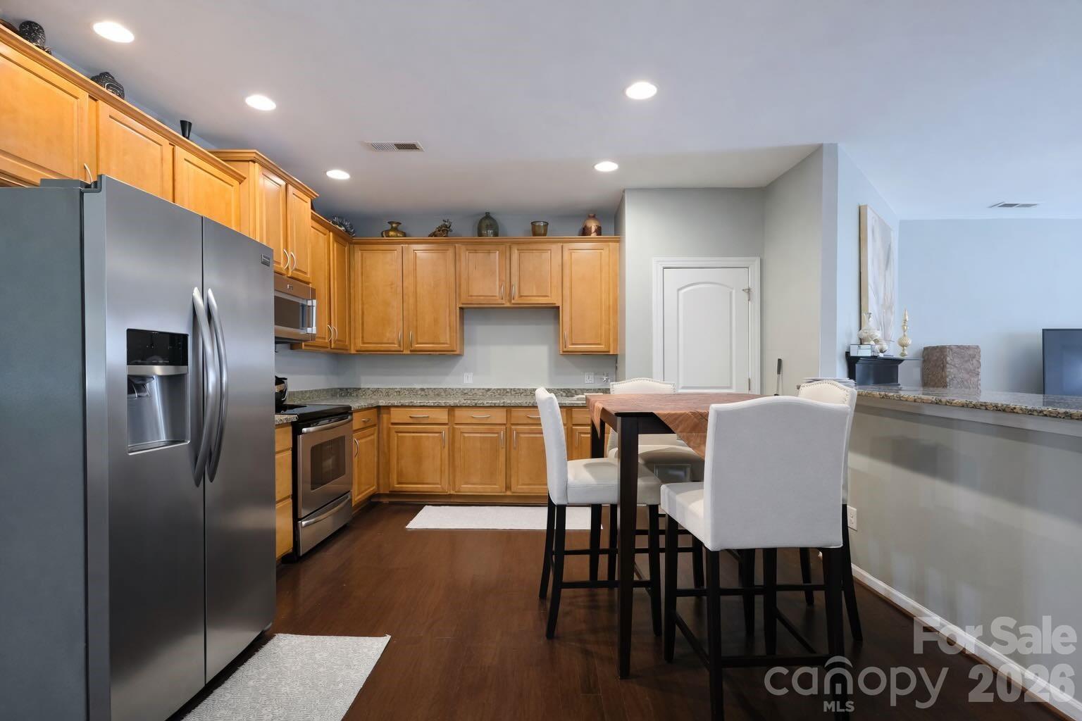 5670 Stafford Road Charlotte, NC 28215 - Photo 6 of 14 a kitchen with stainless steel appliances granite countertop a refrigerator a sink a stove a dining table and chairs