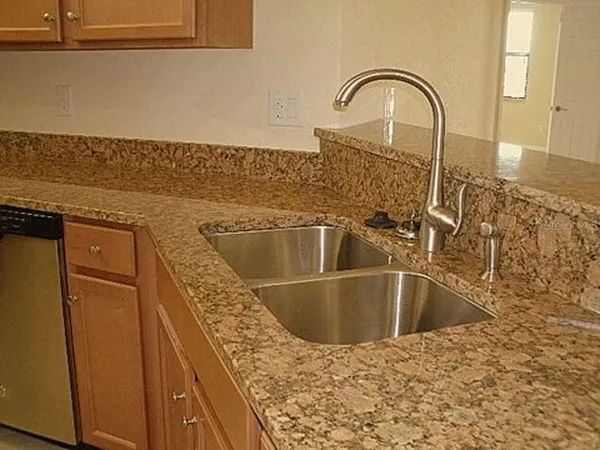 a close view of a sink a faucet and appliance in the kitchen