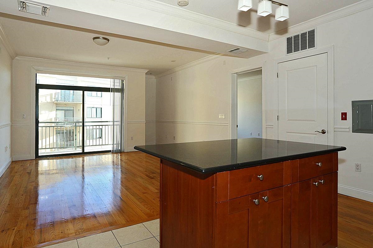 85 Maple Street, Unit 2A Weehawken, NJ 07086 - Photo 2 of 11 a kitchen with granite countertop a sink window and cabinets
