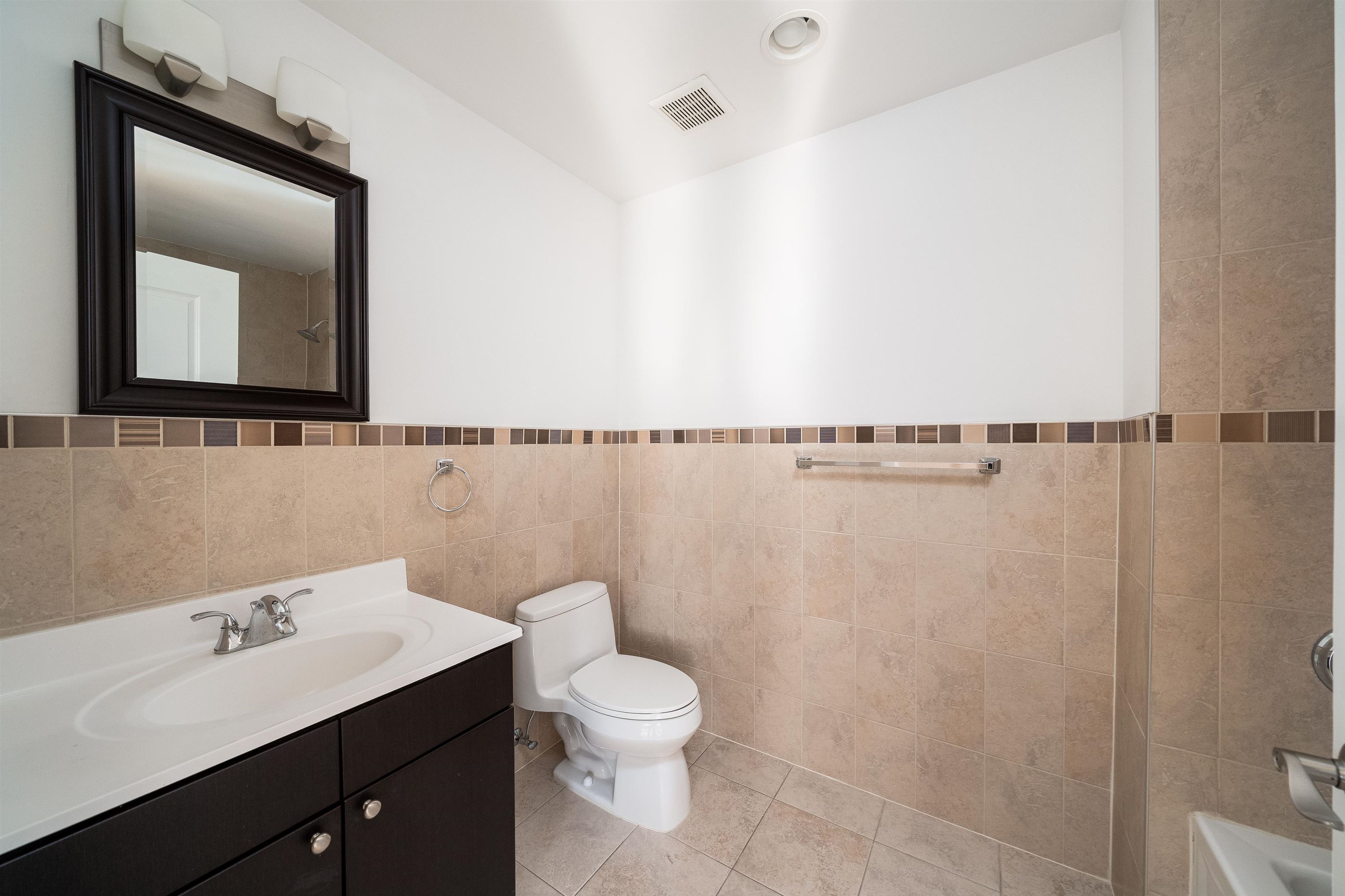 85 Maple Street, Unit 2A Weehawken, NJ 07086 - Photo 6 of 11 a bathroom with a toilet sink and mirror