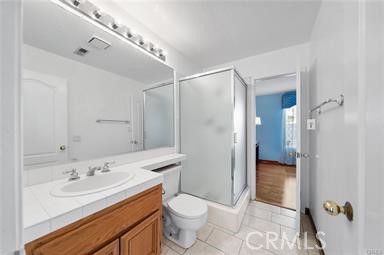 1611 San Almada Road Corona, CA 92882 - Photo 5 of 9 a bathroom with a sink a toilet a mirror and shower