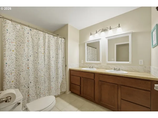 a bathroom with a double vanity sink mirror and shower