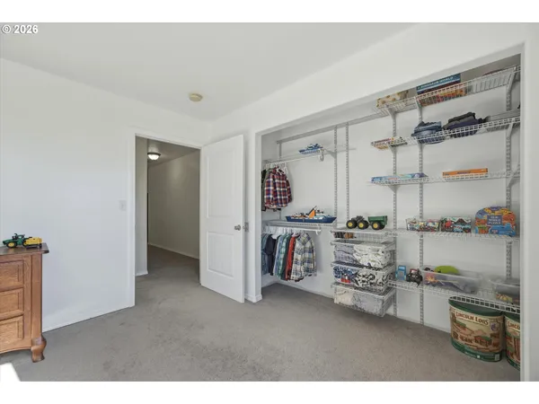 a spacious bedroom with a bed and wooden floor