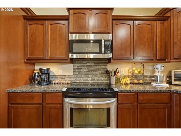 a kitchen with granite countertop stainless steel appliances a stove a sink and dishwasher
