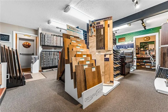 a view of an empty room with wooden floor and windows