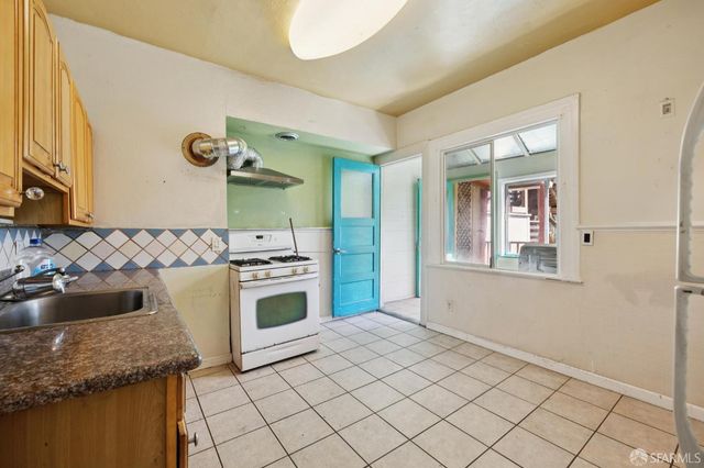 a kitchen with a sink a stove and cabinets