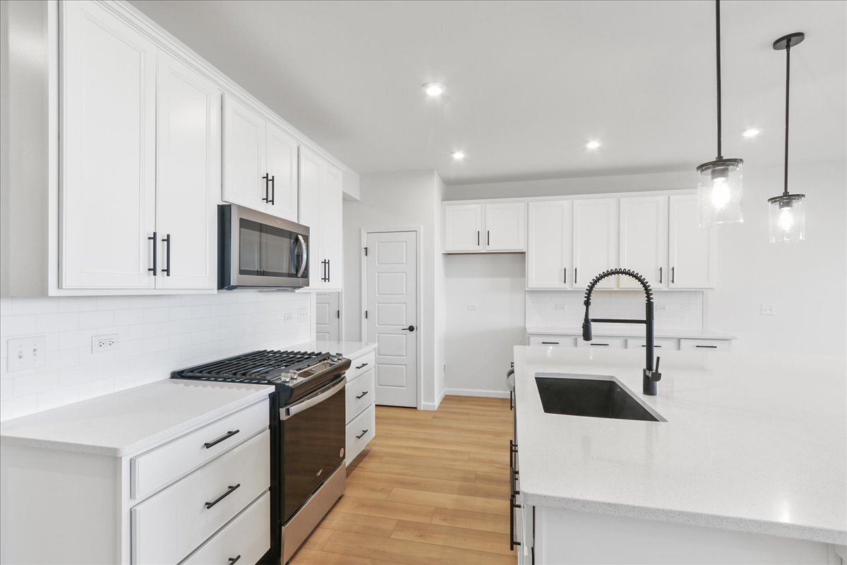 2216 Ryegrass Lane, Unit 78002 Bolingbrook, IL 60490 - Photo 5 of 29 a kitchen with white cabinets stainless steel appliances and sink