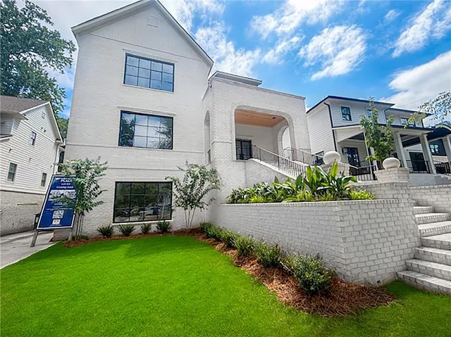 a front view of a house with a garden and plants