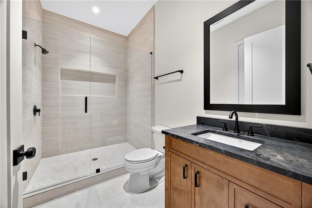 1366 Wessyngton Road Northeast Atlanta, GA 30306 - Photo 20 of 29 a bathroom with a granite countertop sink a toilet and shower