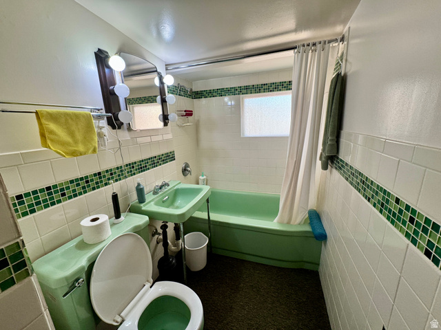 178 Walnut Lane Moab, UT 84532 - Photo 20 of 25 Bathroom featuring white subway tile walls with a decorative green mosaic accent, a green pedestal sink, a green toilet, and a green bathtub with a shower curtain