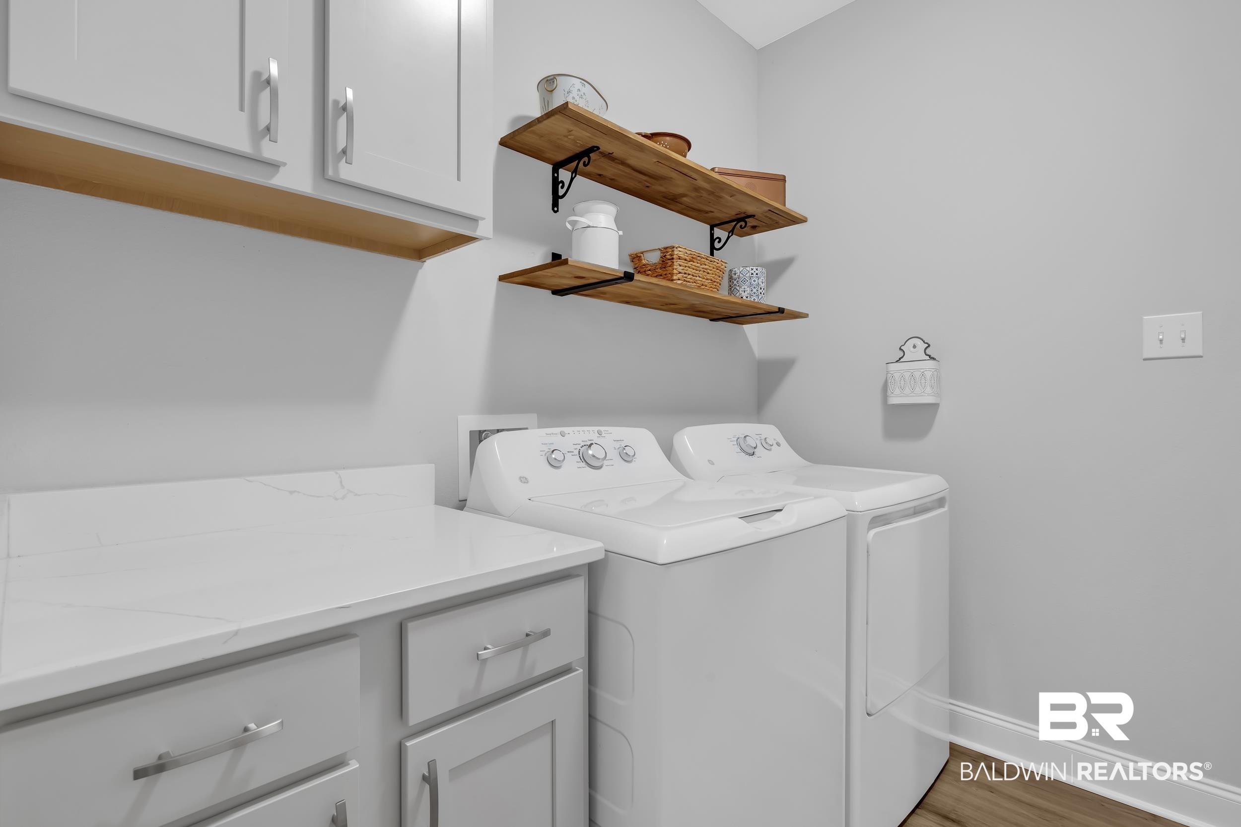 1176 Stella Road Foley, AL 36535 - Photo 22 of 40 Laundry room featuring cabinet space, light wood-style flooring, and washer and clothes dryer
