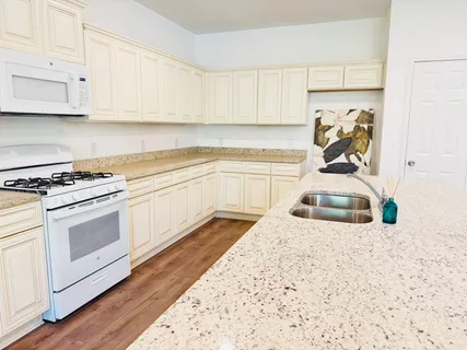 a kitchen with kitchen island granite countertop lots of counter top space and wooden floor