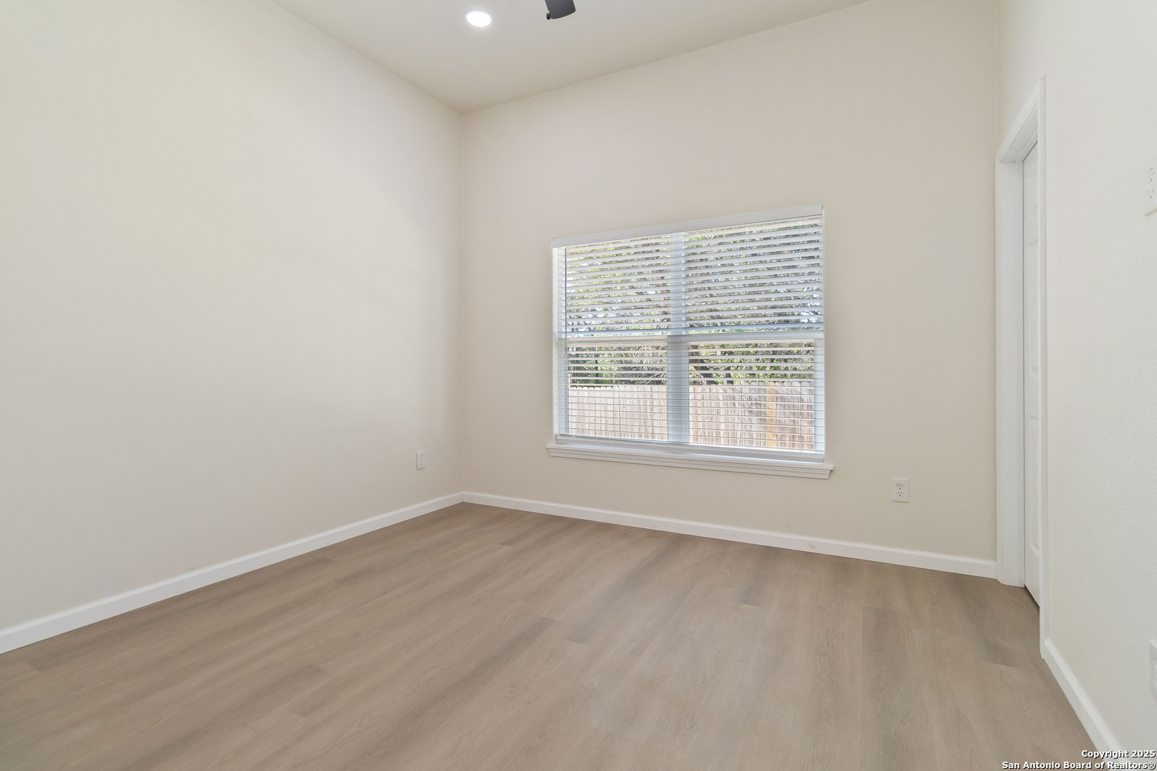 324 Ridgerock Drive, Unit 1 Canyon Lake, TX 78133 - Photo 14 of 21 an empty room with wooden floor and windows