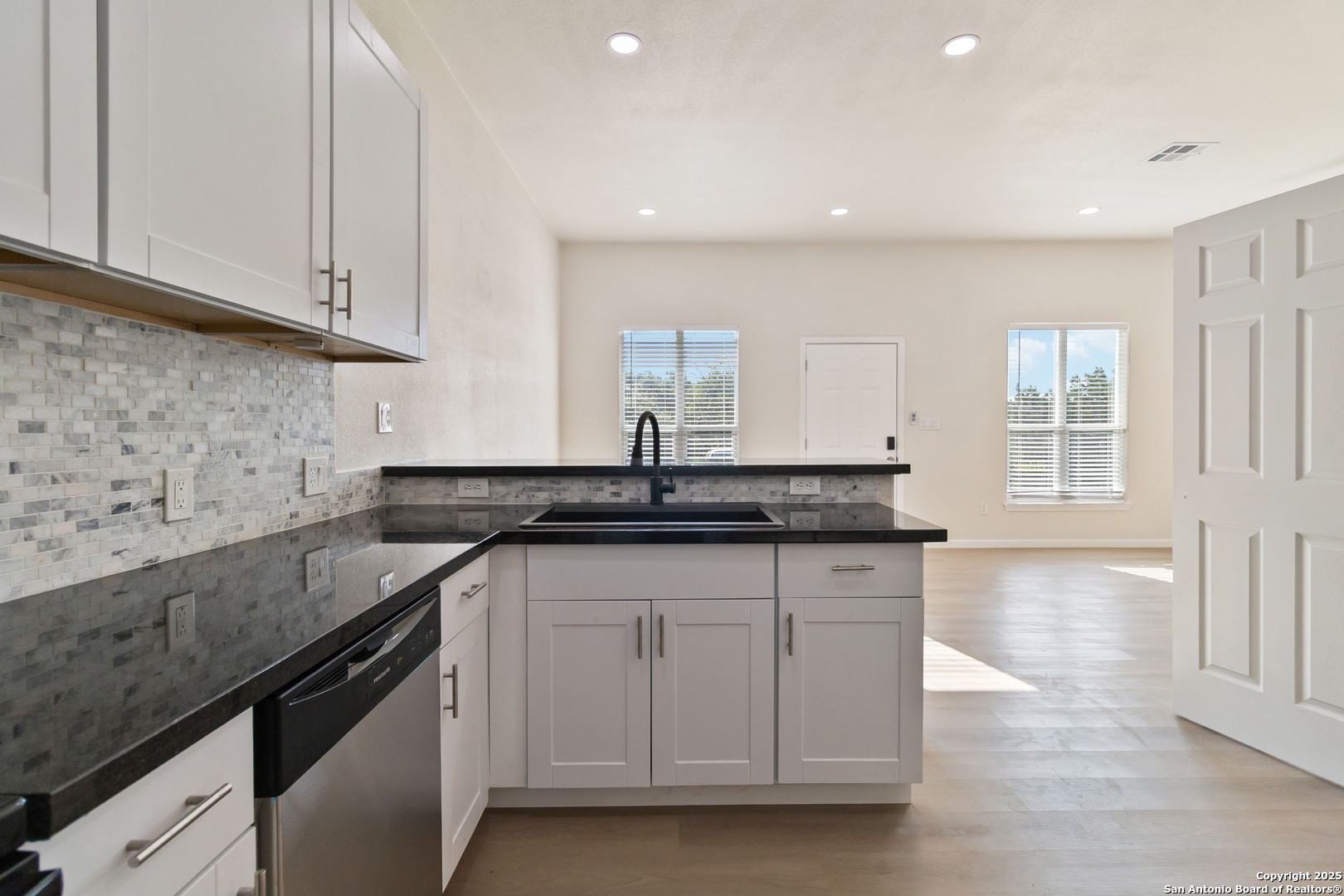324 Ridgerock Drive, Unit 1 Canyon Lake, TX 78133 - Photo 6 of 21 a kitchen with granite countertop a sink white cabinets and a granite counter tops
