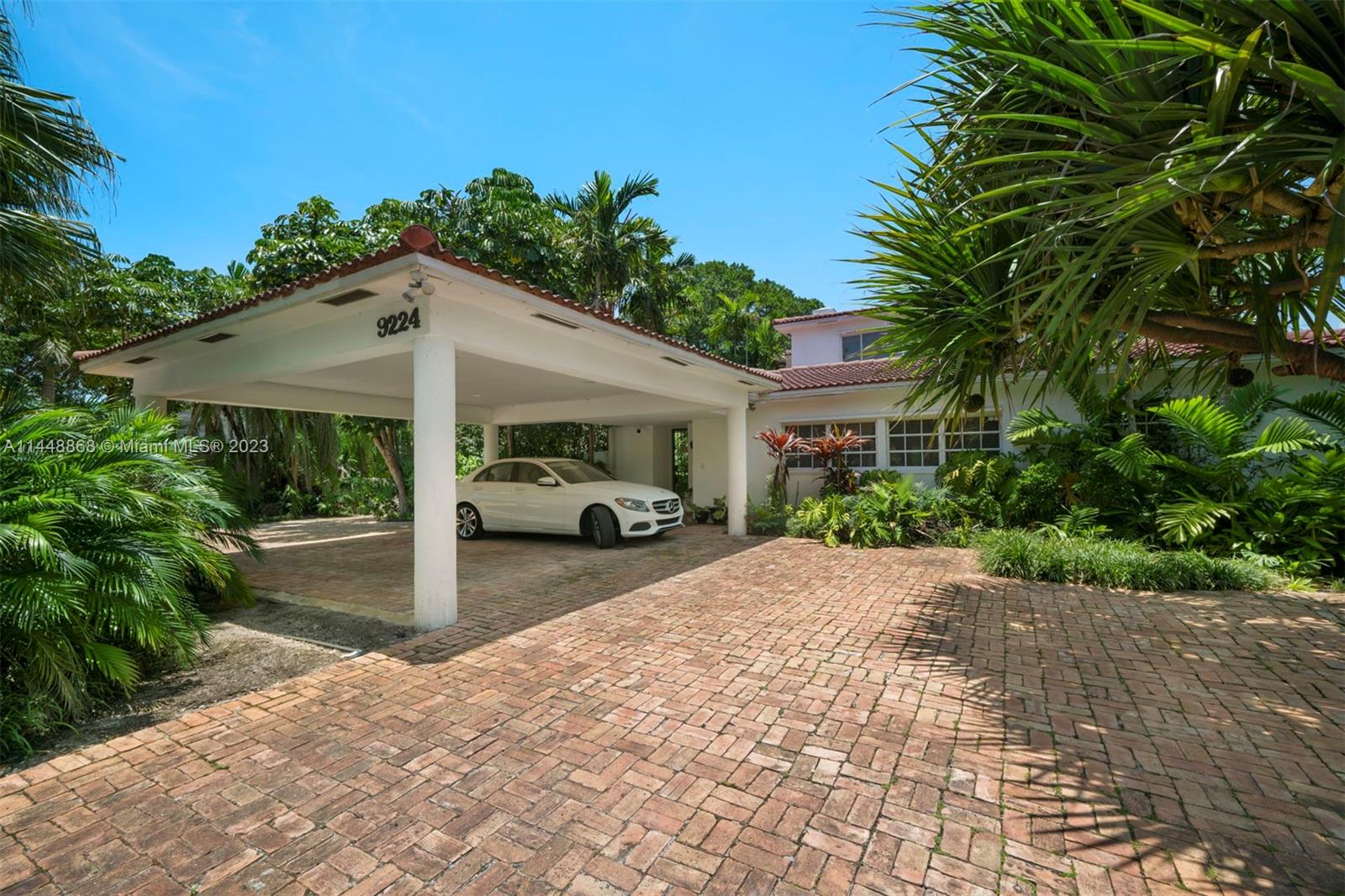 9224 Bay Drive Surfside, FL 33154 - Photo 7 of 11 a front view of a house with a yard and potted plants