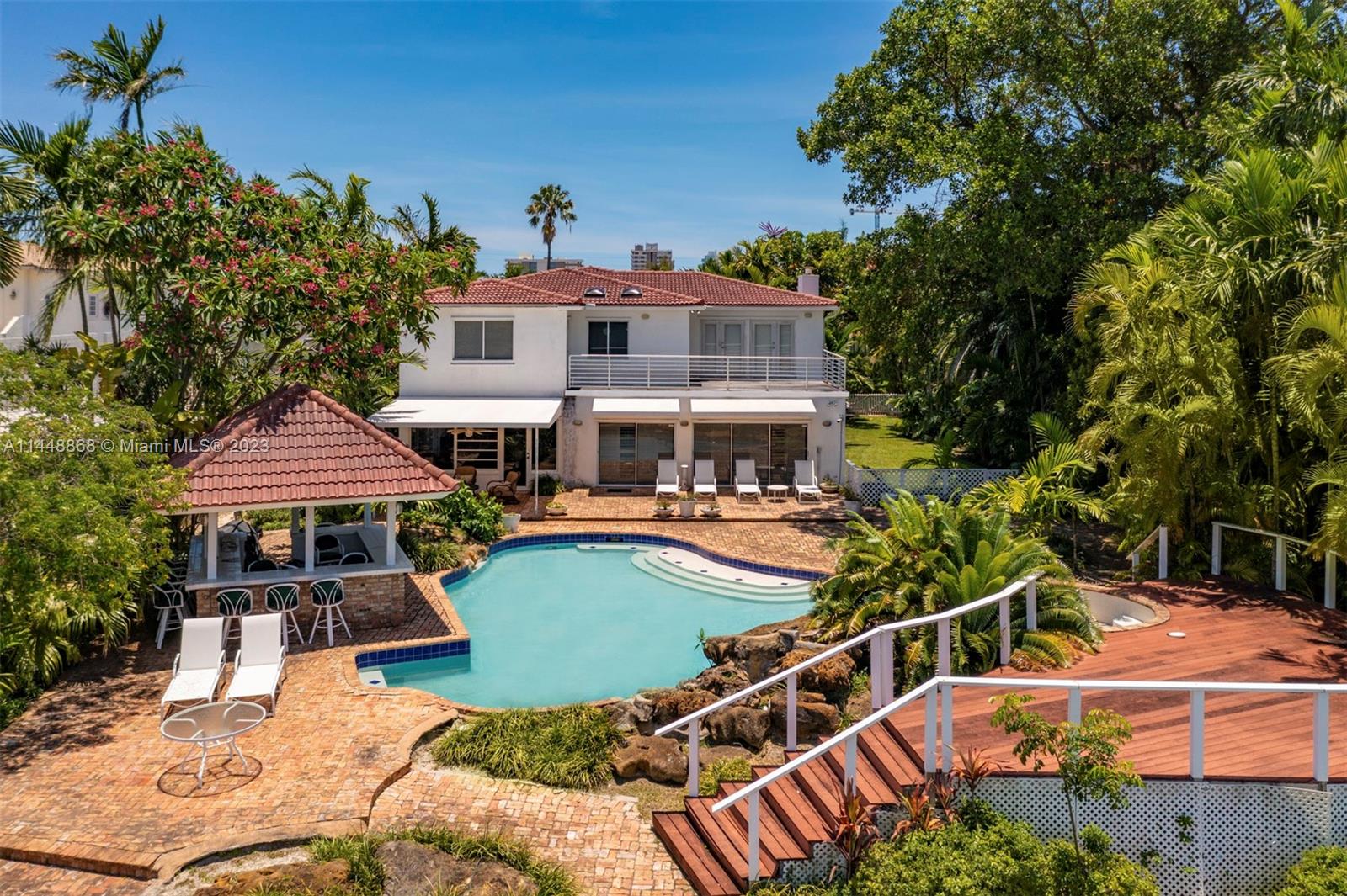 9224 Bay Drive Surfside, FL 33154 - Photo 8 of 11 a front view of a house with garden