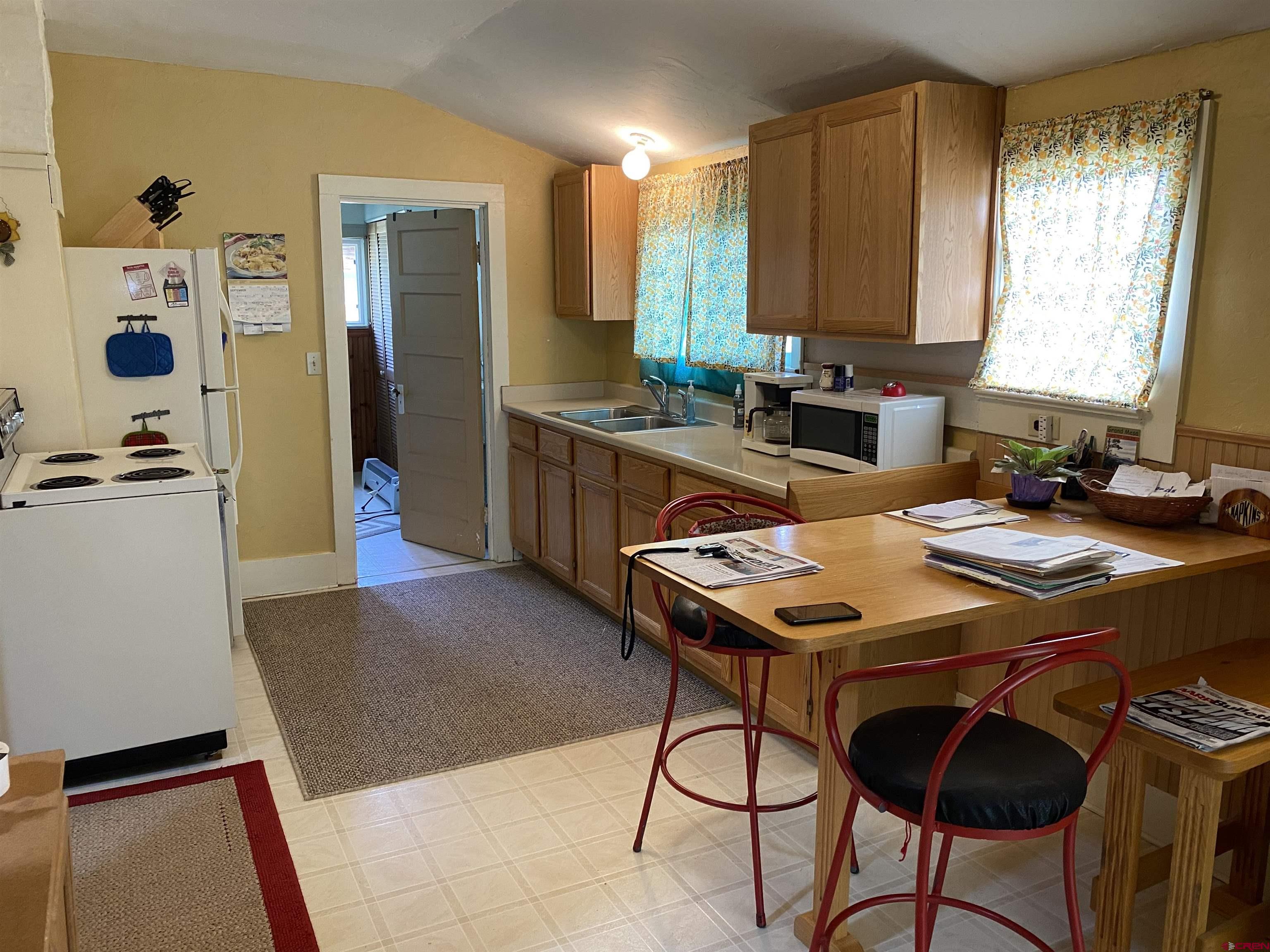 21236 Lanning Road Austin, CO 81410 - Photo 9 of 21 a room with a table chairs and a refrigerator