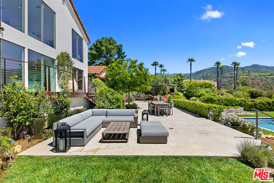 27450 Calicut Road Malibu, CA 90265 - Photo 28 of 59 a view of a patio with couches table and chairs with potted plants