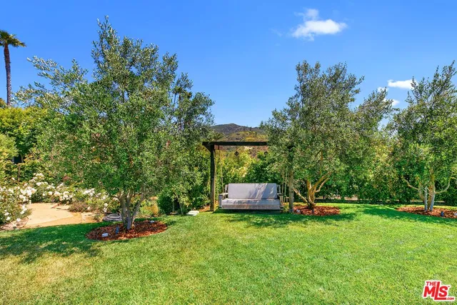 an aerial view of residential houses with outdoor space and trees