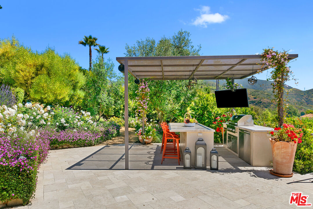 27450 Calicut Road Malibu, CA 90265 - Photo 33 of 59 a patio with table and chairs and potted plants