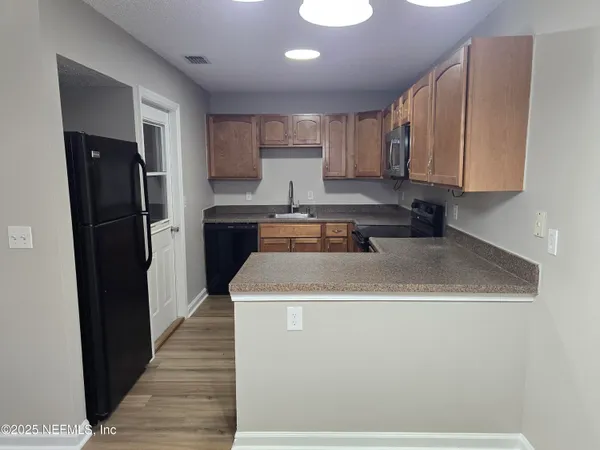 a kitchen with a sink a refrigerator and cabinets