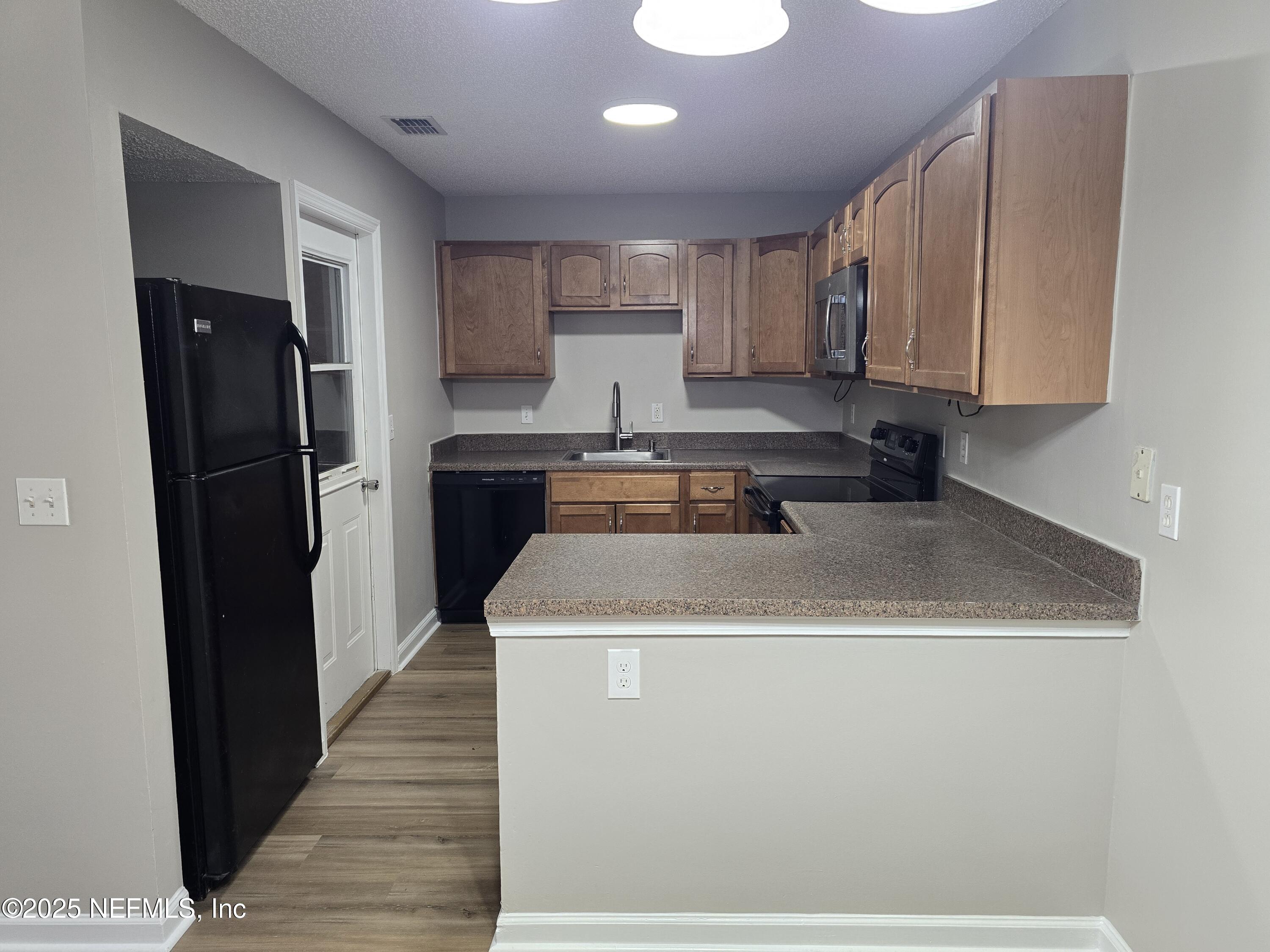744 Palm Hammock Circle St. Augustine, FL 32095 - Photo 13 of 34 a kitchen with a sink a refrigerator and cabinets