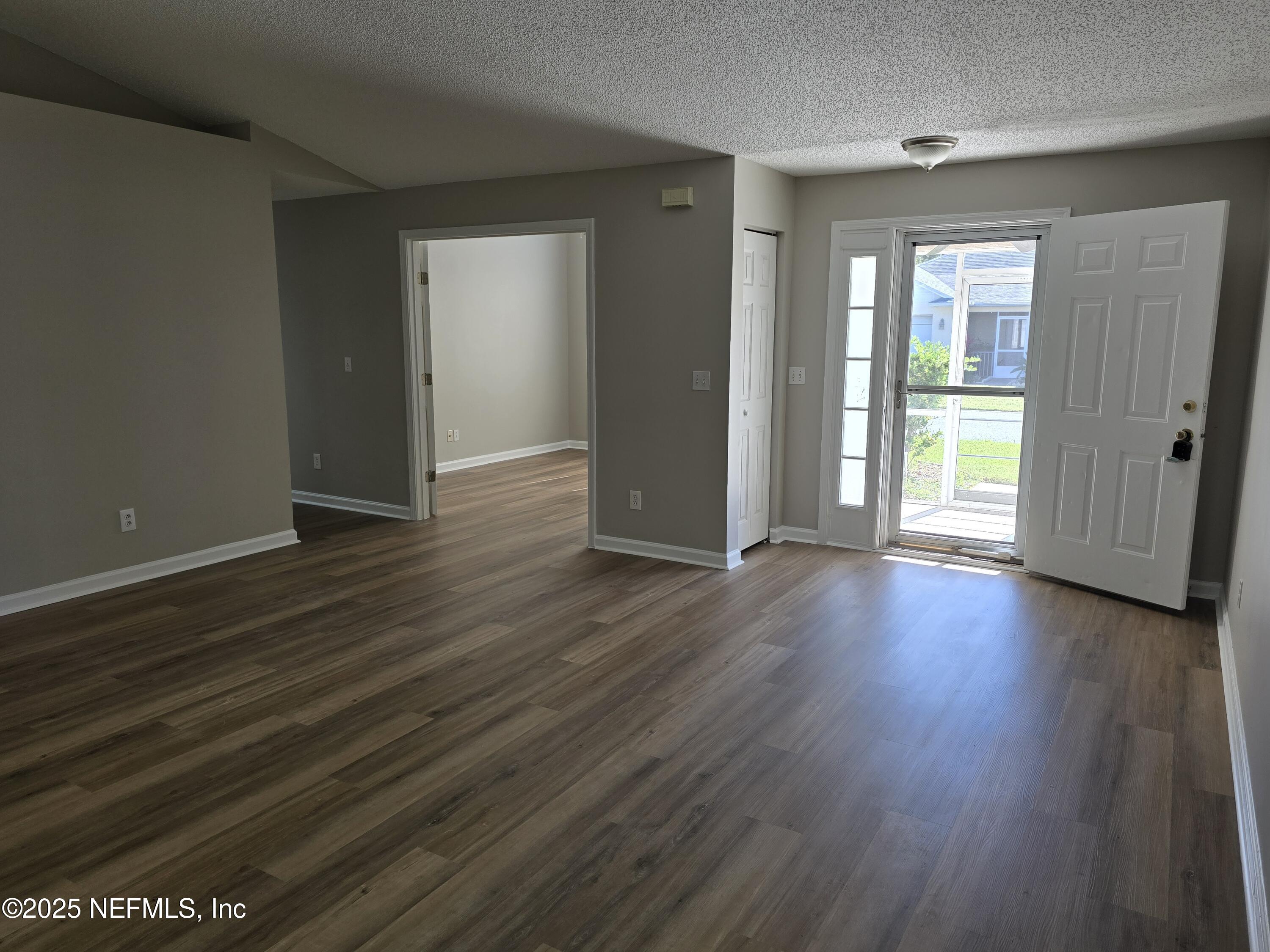 744 Palm Hammock Circle St. Augustine, FL 32095 - Photo 14 of 34 an empty room with wooden floor and windows