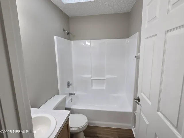 a white toilet sitting next to a bath tub