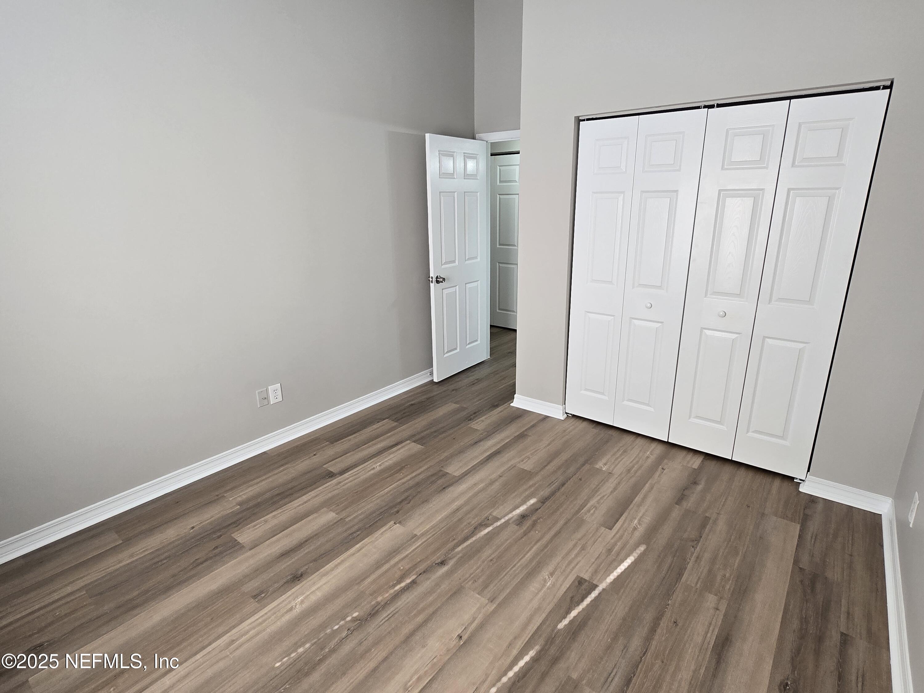 744 Palm Hammock Circle St. Augustine, FL 32095 - Photo 18 of 34 a view of an empty room with wooden floor and a window