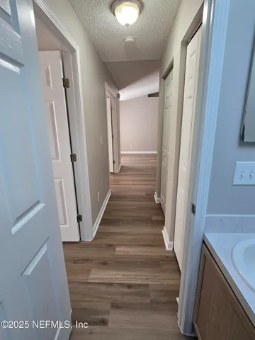 a view of a hallway with wooden floor and staircase