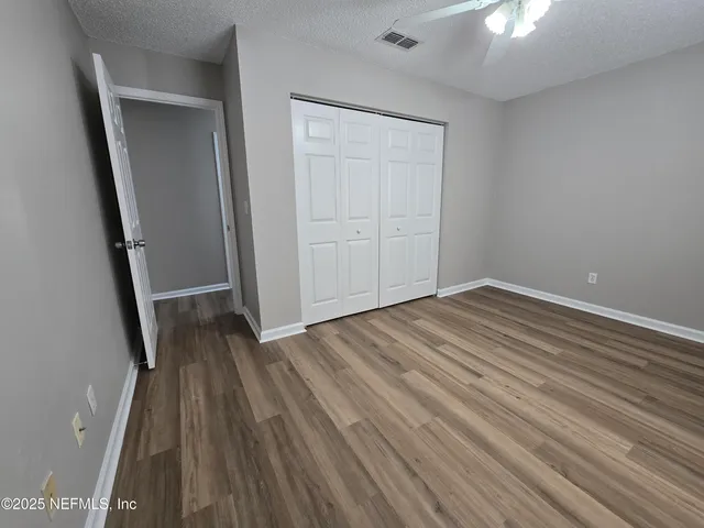 an empty room with wooden floor and entrance