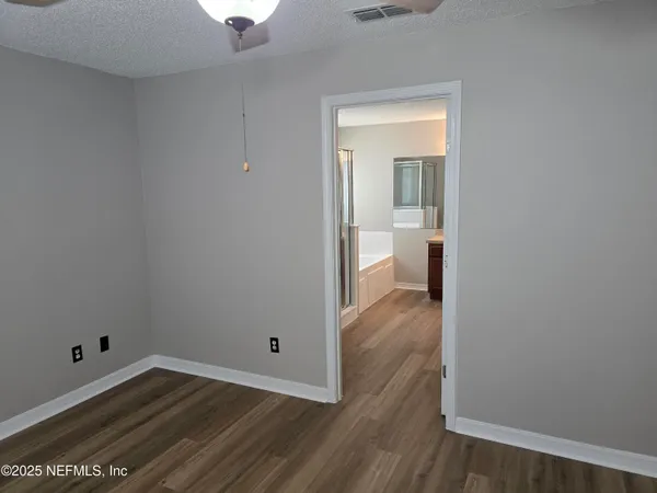a view of a room with wooden floor and a bathroom
